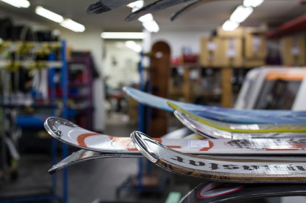 Hier warten Skis und Snowboards auf ihr Service.