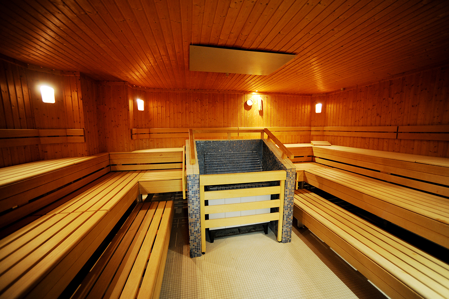 La stufa, decorata con piastrelle, conferisce alla sala grande per la sauna un tocco di stile Liberty. Foto: IKB