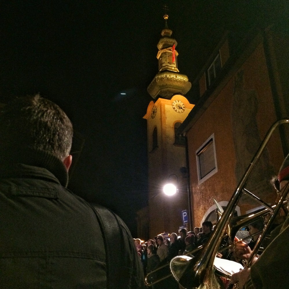 Am Kirchplatz wird die 2. Strophe des Zachäus- und des Kirchtagsliedes mit Unterstützung einer Bläsergruppe dargeboten.