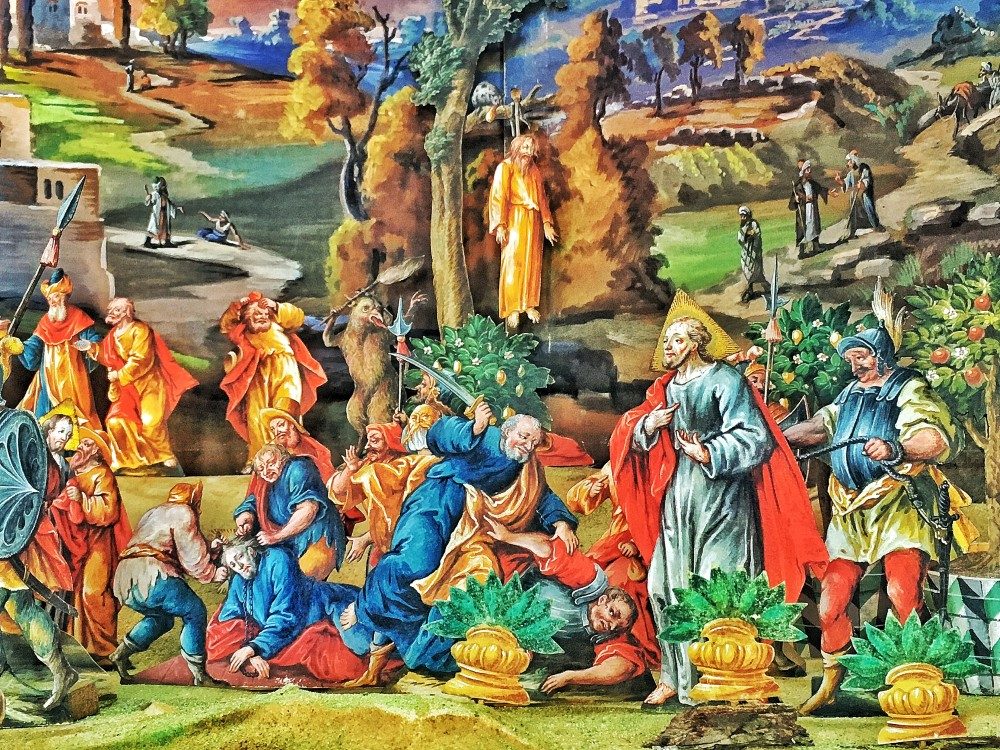 Lebensfrohe Farben und eine künstlerisch sehr anspruchsvolle Gestaltung verleihen den Papierfiguren der Fastenkrippe ein einzigartige Dynamik. Die Darstellung ist oft blutig und nicht zimperlih. Wie zum Beispiel hier im Hintergrund: der erhängte Judas, der Teufel in Form eines Fabeltieres und eine Katze, die sich der Silberlinge annimmt.