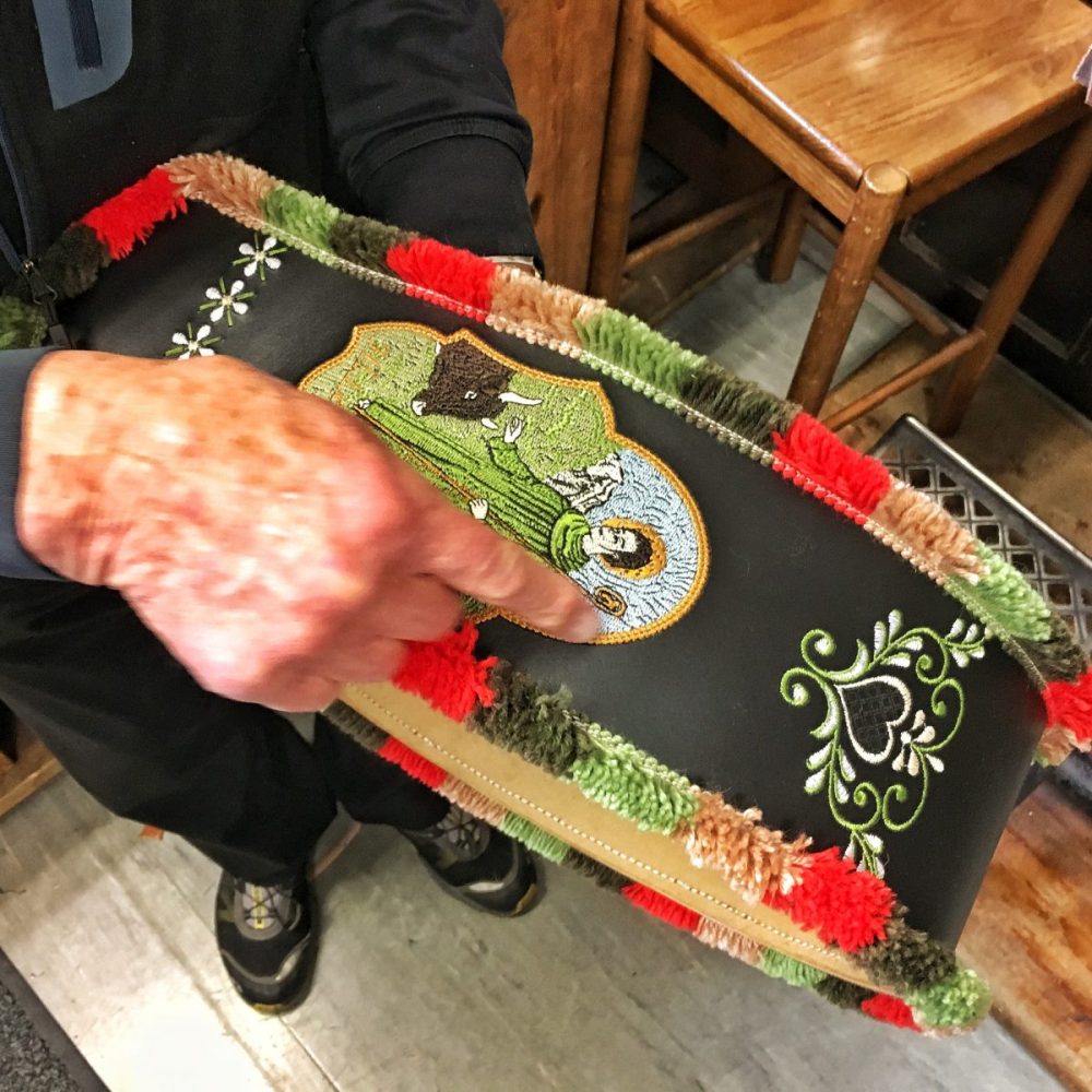 Bestickter Glockenriemen aus Leder Bestickte Glockenriemen aus dem Hause Schmarda haben Tradition. Auch die kunstvollen Bosamenten, die farbigen Borten sind selbstverständlich handgefertigt.