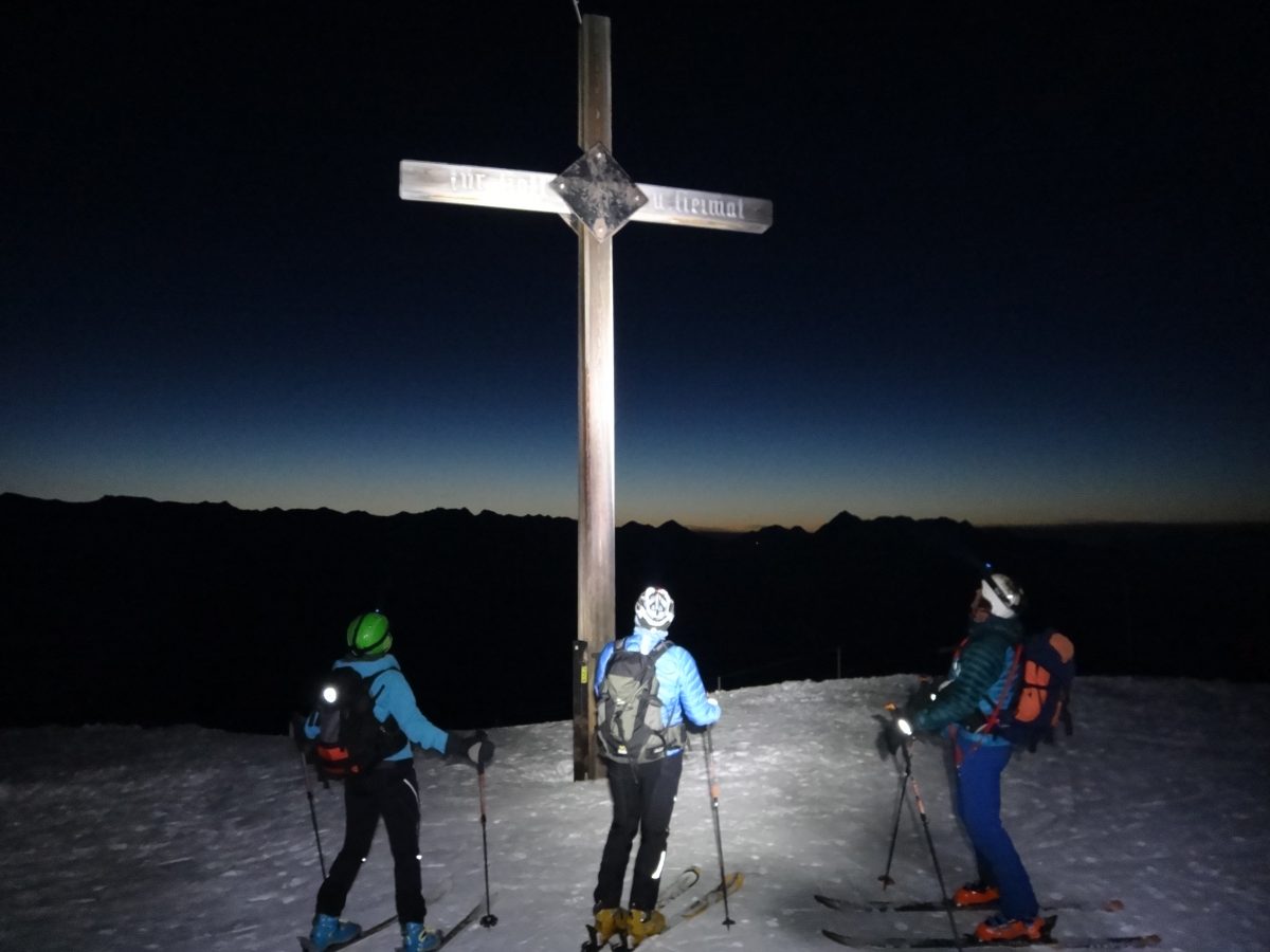 Skitourengeher vor Gipfelkreuz