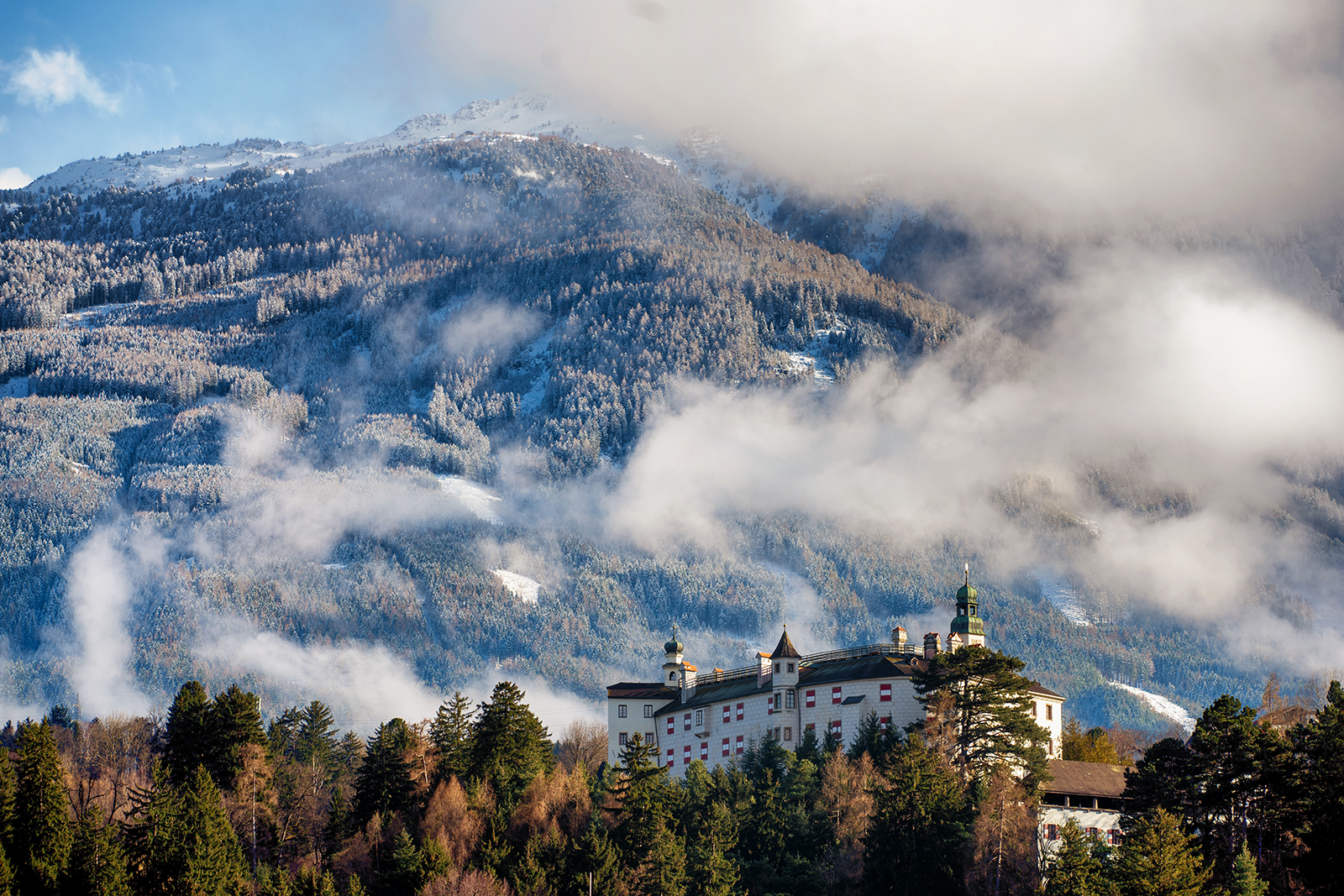 Schloss Ambras bereits im Grünen und die Berge schneeweiß