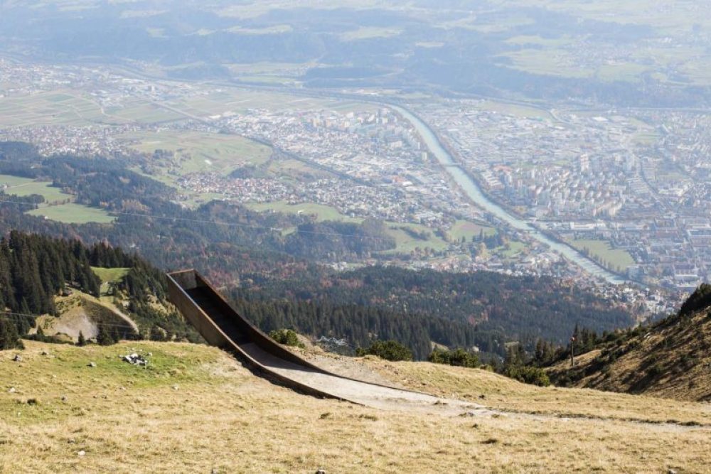 Rostbraun und geschwungen fügt sich die Plattform ein in den Berg.