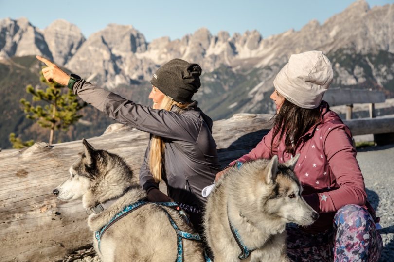 Alpinsportbegeisterte Mädels mit Hunden.