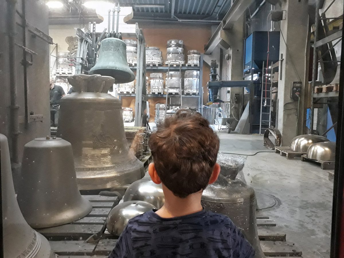 Junge beobachtet Glockengießer bei der Arbeit