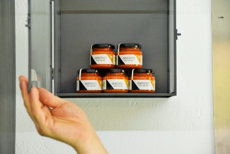 Das Nebenprodukt ist unter Verschluss: Die extrem scharfe Habaneropaste. „Die brennt dreimal“, verspricht der Chef, „einmal vorne, einmal hinten und einmal der Kanalratte in den Augen“, schmunzelt er. Wenn Thomas sie herstellt, muss er wegen der starken ätherischen Öle eine Gasmaske tragen. Foto: Tamara Kainz