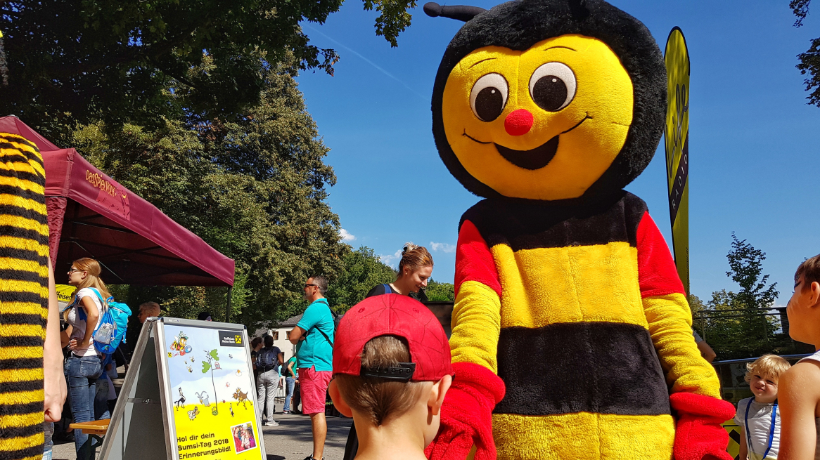 Das Maskottchen Sumsi begrüßt die Kinder im Alpenzoo