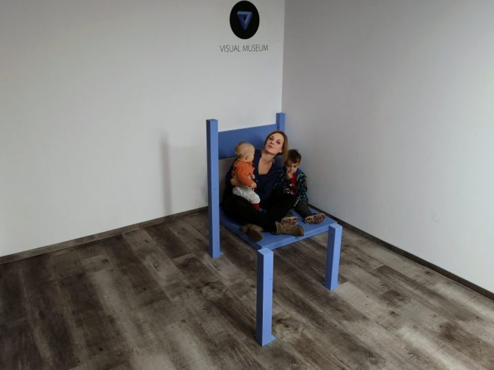 Familie sitzt auf überdimensionalem Stuhl