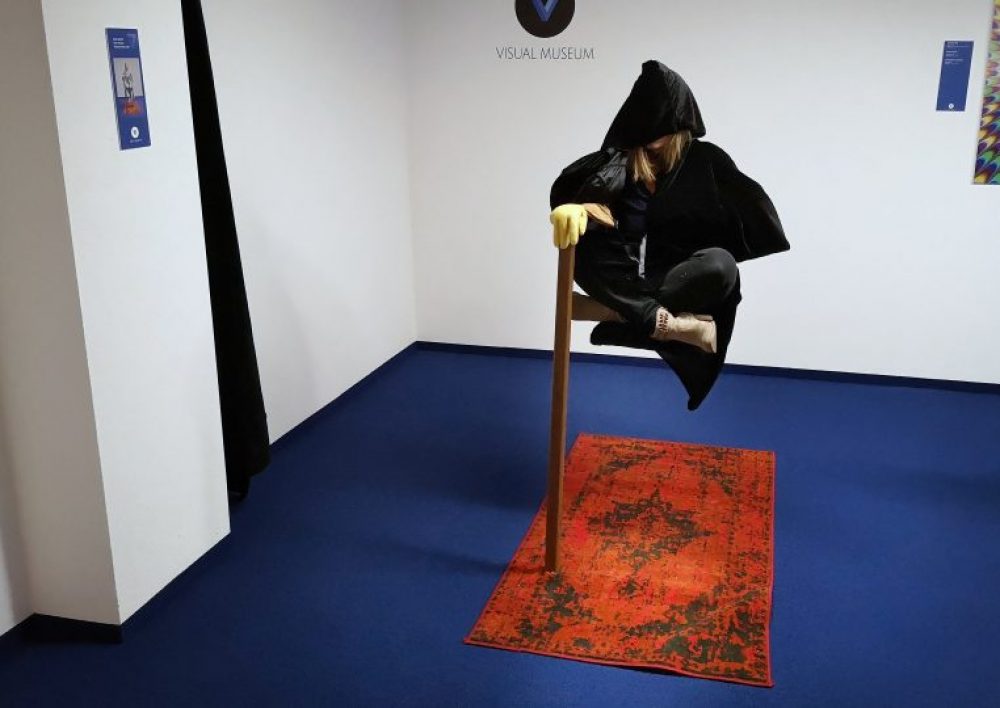 als Magier verkleidete Frau schwebt im Visual Museum