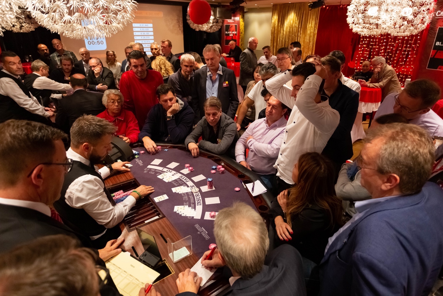 Blackjack am Tisch: Sieben Spieler und viele Zuseher.