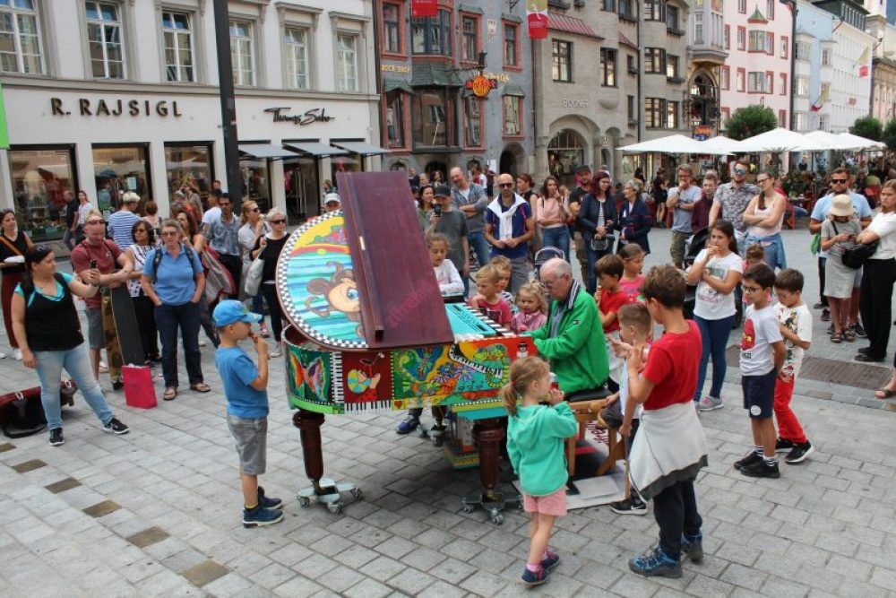 Piano player surrounded by people