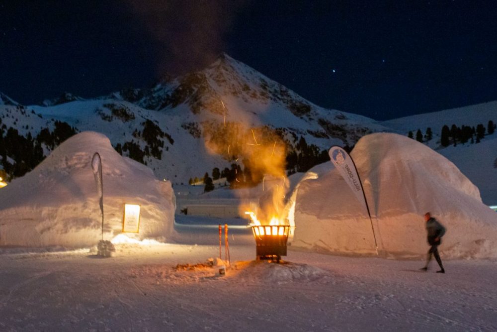 Stimmungsvoll erleuchtet die Feuerschale das Iglu Dorf.
