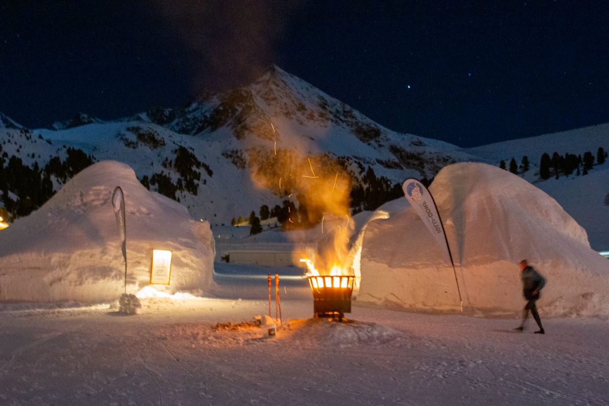 Stimmungsvoll erleuchtet die Feuerschale das Iglu Dorf.