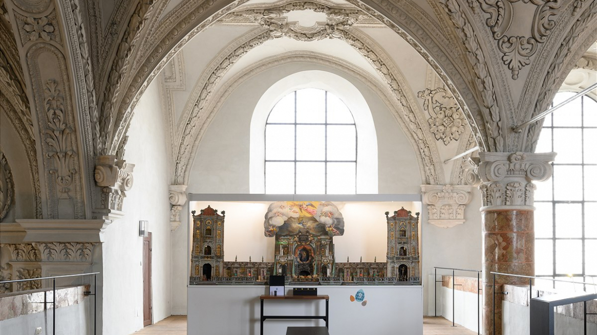 Una stazione del percorso della mostra „Ostern feiern – hier und anderswo“ al Tiroler Volkskunstmuseum di Innsbruck porta nella galleria all’interno della Hofkirche, la chiesa di corte. Nella foto un cosiddetto Fastenkrippe, una sorta di „presepe“ di Pasqua con le scene della passione © Wolfgang Lackner